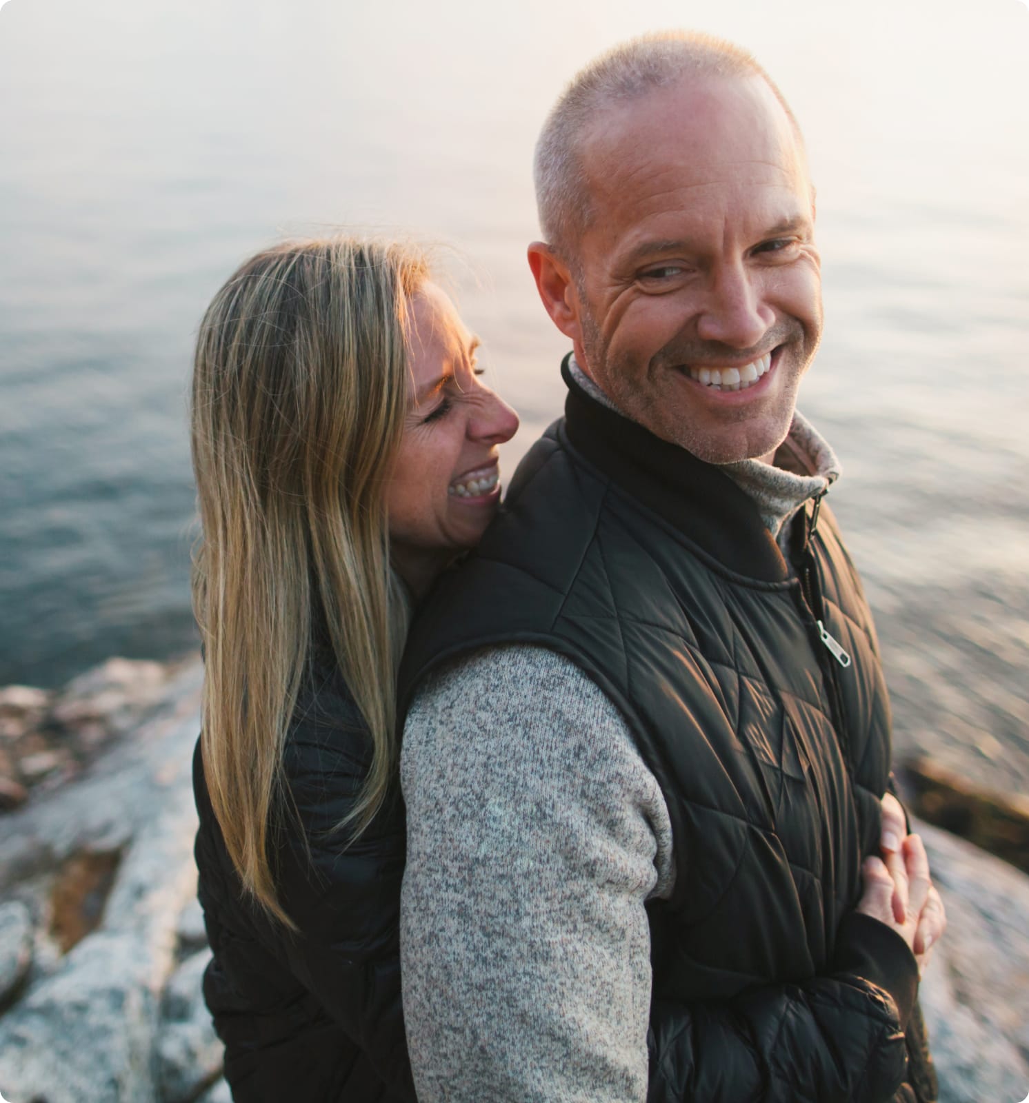 Woman hugging man by the ocean