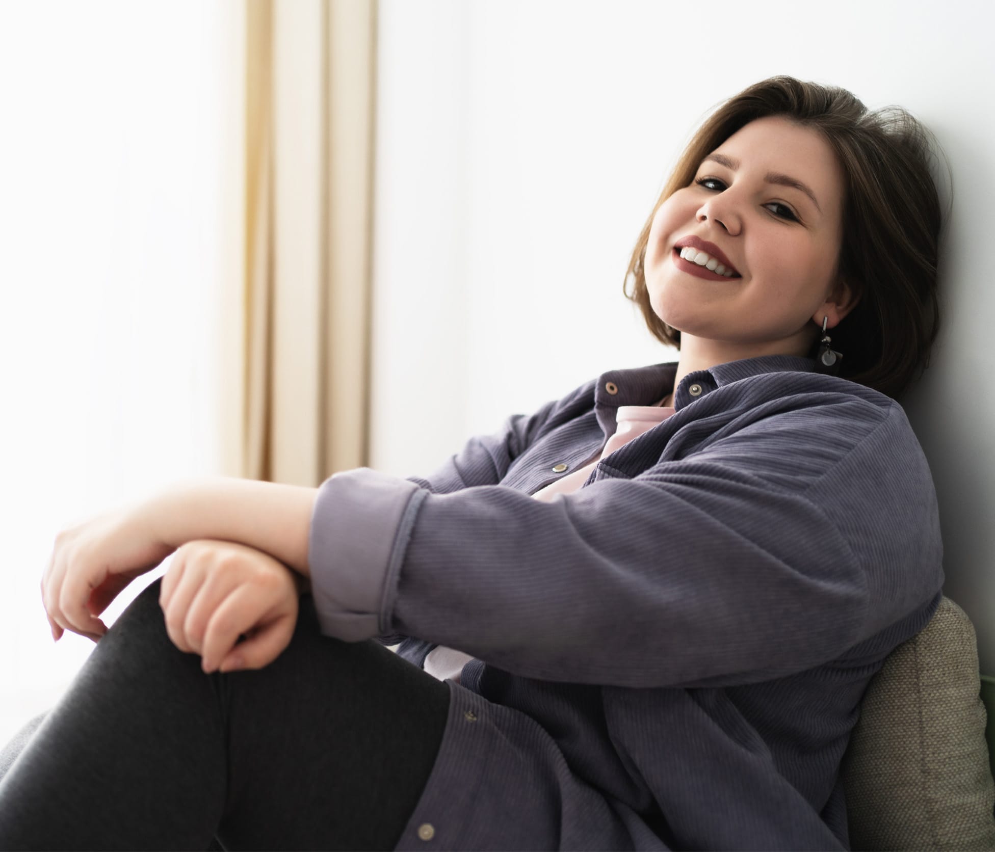 Woman smiling and leaning against wall