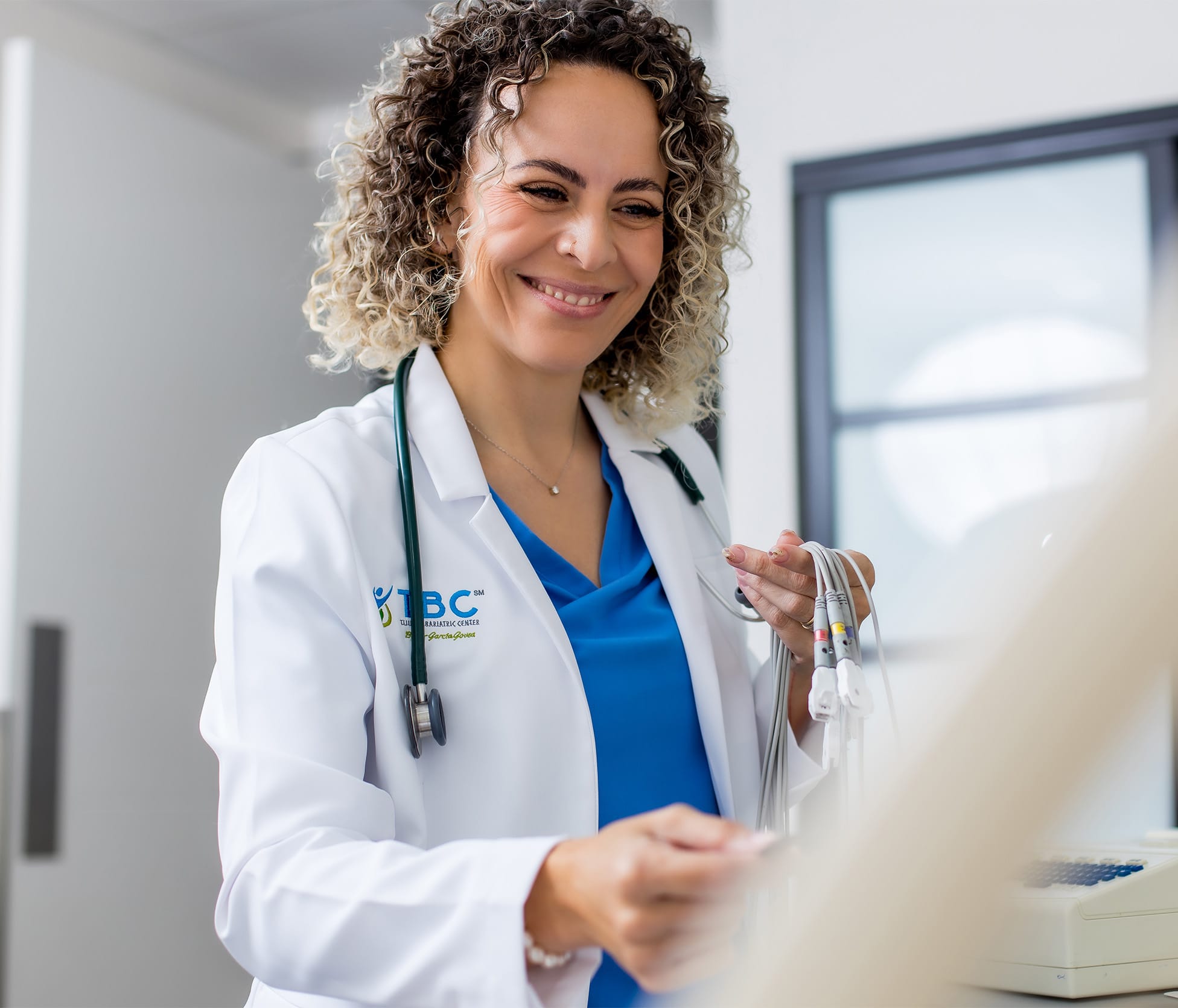 Dr. Paola Velazco Gerardo Smiling and standing over patient
